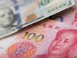 Đồng 100 USD của Mỹ và 100 NDT của Trung Quốc. Ảnh: AFP.