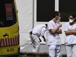 Hai nhân viên y tế trò chuyện cạnh xe cứu thương bên ngoài bệnh viện La Paz ở Madrid hôm 23/3. Ảnh: AFP.