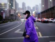 Một phụ nữ đi lại trên đường phố Thượng Hải (Trung Quốc) cuối tháng 2. Ảnh: Reuters.