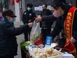 Nhân viên đứng bán tại sạp hàng dựng tạm trước cửa một trung tâm thương mại ở Bắc Kinh