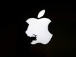 Một phụ nữ nhìn vào màn hình điện thoại di động của mình trước logo bên ngoài Apple Store ở Thượng Hải, Trung Quốc. Ảnh: Reuters.