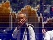 Một người đàn ông nhìn bảng điện tử trên đường phố Tokyo. Ảnh: Reuters.