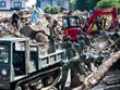 Lực lượng cứu hộ và binh sĩ dọn dẹp đống đổ nát trên một con phố sau trận lụt ở Kumano, tỉnh Hiroshima, ngày 9/7. Ảnh: AFP.