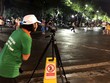 Nhân viên công ty môi trường ghi hình người xả rác bừa bãi ở phố đi bộ Hồ Gươm. Ảnh: N.H.