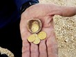 Các đồng xu vàng được giấu trong chiếc bình nhỏ. Ảnh: Xinhua.