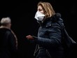 Một phụ nữ đeo khẩu trang tại một ga tàu ở Paris (Ảnh: AFP).