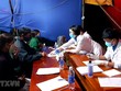 Sinh viên tình nguyện hướng dẫn người dân khai báo y tế tại chốt kiểm soát y tế thị xã Hương Trà. (Ảnh: Tường Vi/TTXVN).