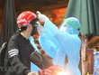 Nhân viên y tế kiểm tra và sát khuẩn cho những người vào bênh viện. (Ảnh: Dương Giang/TTXVN).
