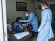 Nhân viên y tế kiểm tra tình trạng bệnh nhân mắc COVID-19. (Ảnh: AFP/TTXVN).