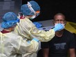 Nhân viên y tế xét nghiệm một lao động nhập cư tại Singapore ngày 27/4. Ảnh: AFP.