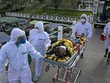 Nhân viên y tế chuyển bệnh nhân mắc COVID-19 tới một bệnh viện ở bang Para, Brazil. (Ảnh: AFP/TTXVN).