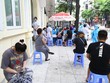 Người về từ Đà Nẵng chờ xét nghiệm nhanh tại phường Bách Khoa. (Ảnh: Minh Quyết/TTXVN).