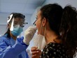 Nhân viên y tế lấy mẫu xét nghiệm nCoV cho một người dân ở Madrid, Tây Ban Nha, ngày 17/8. Ảnh: Reuters.