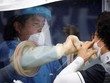 Người phụ nữ được lấy mẫu xét nghiệm nCoV tại một phòng khám dã chiến ở Seoul, Hàn Quốc, ngày 26/8. Ảnh: Reuters.