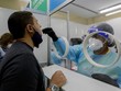 Nhân viên y tế lấy mẫu xét nghiệm Covid-19 cho một người đàn ông ở Sân bay Quốc tế Tocumen, Panama City, thủ đô của Panama hôm 12/10. Ảnh: AFP.