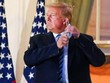 Cựu Tổng thống Donald Trump kéo khẩu trang khi xuất hiện tại ban công Nhà Trắng sau 3 ngày điều trị tại bệnh viện. (Ảnh: Reuters).