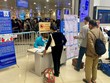 Các hãng hàng không bố trí bàn hỗ trợ khai báo y tế ngay phía ngoài gần lối vào xếp hàng qua cửa kiểm soát an ninh hàng không. (Ảnh: CTV/Vietnam+).