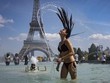 Một cô gái giải nhiệt trước khu vực tháp Eiffel trong đợt nắng nóng cao điểm ở Pháp năm 2019 (Ảnh minh họa: EPA).