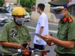 Trên tuyến đường Cầu Diễn (Bắc Từ Liêm, Hà Nội), lực lượng chức năng đã lập hàng rào chia thành 2 làn đường để tiến hành kiểm soát. Ngày hôm nay, Tổ công tác sẽ tiến hành tuyên truyền cho người dân về quy định mới trong Chỉ thị 20 đã áp dụng để chống dịch. (Ảnh: Minh Sơn/Vietnam+).
