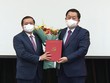 Ông Nguyễn Trọng Nghĩa trao quyết định và tặng hoa chúc mừng ông Lại Xuân Môn.