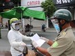 Một người phụ nữ đi chợ trình giấy có giấy tiêm đủ vaccine cho lực lượng kiểm tra trên đường Yersin, thành phố Thủ Dầu Một. (Ảnh: Chí Tưởng/TTXVN).