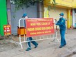 Lực lượng chức năng thực hiện dỡ bỏ phong tỏa cho 20 hộ dân tại khu phố 2, phường Xuân Thanh. (Ảnh: Lê Xuân/TTXVN).