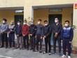 Đối tượng cầm đầu Nguyễn Xuân Tiến (đứng thứ 3, từ phải sang) cùng 9 đối tượng khác tại cơ quan công an. (Ảnh: TTXVN phát).