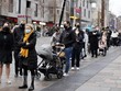 Người dân xếp hàng chờ lấy mẫu xét nghiệm COVID-19 tại London, Anh ngày 18/12/2021. (Ảnh: AFP/TTXVN).