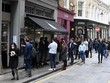 Người dân xếp hàng mua đồ bên ngoài một cửa hàng ở London (Anh), ngày 29/4/2021. (Ảnh: AFP/TTXVN).