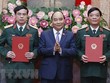 Chủ tịch nước Nguyễn Xuân Phúc, Thống lĩnh các lực lượng vũ trang nhân dân, Chủ tịch Hội đồng Quốc phòng và An ninh, trao Quyết định thăng quân hàm từ Trung tướng lên Thượng tướng đối với đồng chí Ngô Minh Tiến và Lương Đình Hồng. (Ảnh: Thống Nhất/TTXVN).