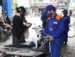 Nhân viên Petrolimex đang bán xăng cho khách hàng. (Ảnh: PV/Vietnam+)