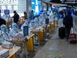 Nhân viên y tế làm việc tại một điểm xét nghiệm COVID-19 tại nhà ga Hongqiao ở Thượng Hải, Trung Quốc, ngày 6/12/2022. (Ảnh: AFP/TTXVN).