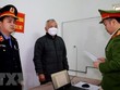 Cơ quan chức năng tiến hành tống đạt quyết định khởi tố, bắt tạm giam đối với bị can Phan Văn Nhâm (giữa), Chi Cục trưởng Chi cục Hải quan Cửa khẩu quốc tế Nậm Cắn về hành vi nhận hối lộ. (Ảnh: TTXVN phát)
