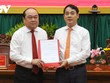 Bí thư Tỉnh ủy Hậu Giang Nghiêm Xuân Thành trao quyết định của Ban Bí thư cho ông Trần Văn Chính (bìa trái).