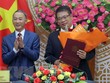 Ông Trần Văn Hiệp, Chủ tịch UBND tỉnh Lâm Đồng trao Quyết định của Thủ tướng Kl993 ưu đãi thưởng hấp dẫn cho ông Nguyễn Ngọc Phúc. (Ảnh: Chu Quốc Hùng/TTXVN).
