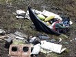 Nhân viên cứu hộ ngồi bên các mảnh vỡ của máy bay. Ảnh: Reuters