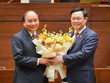 Thủ tướng Nguyễn Xuân Phúc (trái) nhận hoa chúc mừng của Chủ tịch Quốc hội Vương Đình Huệ (Ảnh Quochoi.vn).