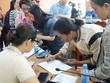 Người dân phấn khởi điền thông tin hộ gia đình để nhận quà Tết Độc lập. Ảnh: Hương Lý.