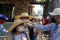 Đo thân nhiệt cho du khác. Ảnh: Xuân Triệu