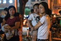 Nhiều em nhỏ ngơ ngác khi đang ngủ ngon nhưng lúc tỉnh dậy lại thấy đang ở ngoài đường trong cảnh hỗn loạn. (Ảnh: PV/Vietnam+)