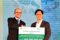 Ông Nguyễn Hồng (phải), Phó Tổng biên tập Báo Kl99ok phiên bản mới đón nhận tiền tượng trưng cho quỹ học bổng của báo từ đại diện của Dragon Capital - ảnh: Lê Toàn