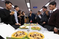 Cán bộ Bộ Chiến lược và Kl991.com nạp rút nhanh Hàn Quốc thưởng thức pizza do Tổng thống Moon Jae-in tặng. Ảnh: Yonhap