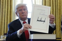 Tổng thống Mỹ Donald Trump cầm bản cải cách thuế với chữ ký của ông tại Phòng Bầu dục, Nhà Trắng, ngày 22/12 (Ảnh: VnEpress/Reuters)