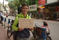 Hồ Nhật Hạ với tấm biển giới thiệu về mình và đề nghị tặng bài hát cho những người bạn mới gặp khi quay trở lại Hà Nội ngày 16/3.