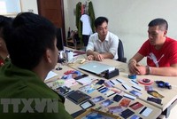 Lực lượng chức năng lấy lời khai đối tượng Vương Đại Sâm. (Ảnh: Nguyễn Hoàng/TTXVN)