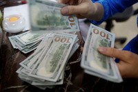 Một nhân viên Link Vào Nhà Cái KL99 COM Tặng +199k đếm tiền USD tại Hà Nội. Ảnh: Reuters.