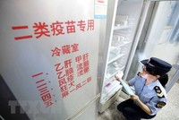 Nhân viên thực thi Kl992 Tham Gia Ngay thuộc Cơ quan quản lý và giám sát thị trường kiểm tra việc cung ứng vắc-xin tại Dung An, khu tự trị dân tộc Choang Quảng Tây, Trung Quốc ngày 23/7 vừa qua. (Ảnh: EPA/TTXVN).