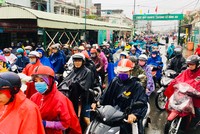 Dòng người xếp hàng dài trong mưa chờ qua phà Cát Lái ở phía bờ Nhơn Trạch, tỉnh Đồng Nai. Ảnh: Hữu Nguyên.