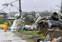 Một công nhân đứng giữa chụp ảnh những mảnh vỡ sau cơn bão Hagibis quét qua Ichihara, Chiba, gần Tokyo. (Nguồn: AP).