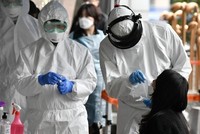 Nhân viên y tế Hàn Quốc lấy mẫu xét nghiệm nCoV cho một phụ nữ ở Seoul ngày 10/3. Ảnh: AFP.